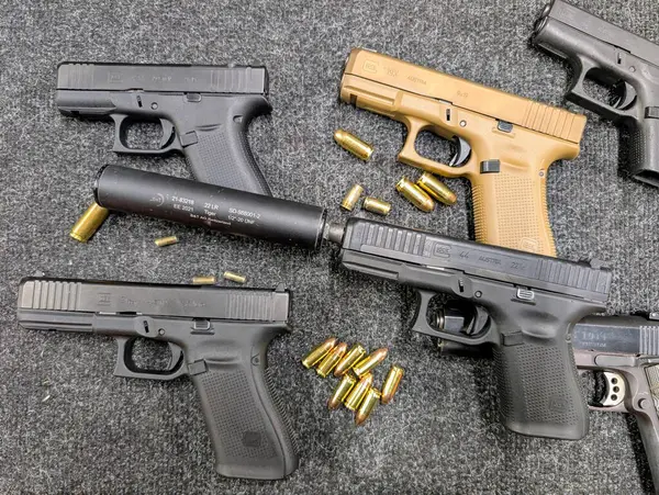 BALTICS - 14 Haziran 2025: Bastırılmış bir sürüm de dahil olmak üzere çeşitli model ve kalibre Glock tabancaları koleksiyonu.