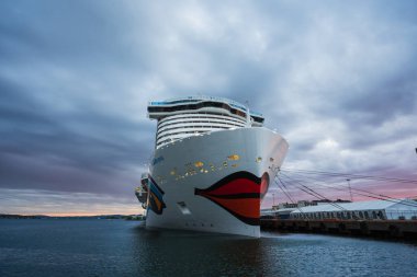 OSLO, NORway - 22 Mayıs 2025: LNG motorlu yolcu gemisi AIDAnova Oslo limanında dramatik bir günbatımı gökyüzüne karşı demirlemiştir..