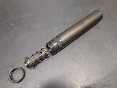 Tezgahta parçalanmış 9mm 'lik tabanca susturucusu. Silah atölyesindeki silah aksesuarlarının temizlenmesi ve bakımı.