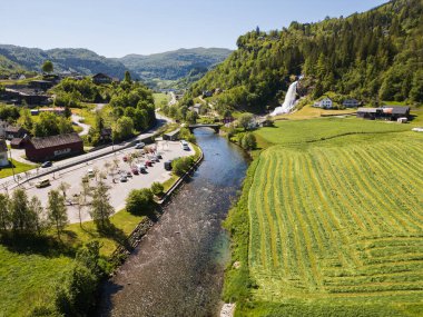 NORHEIMSUND, NORWAY - MAY 19, 2025: An aerial view of the famous Steinsdalsfossen waterfall, a popular tourist attraction, and its surroundings on a sunny spring day.