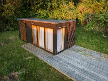 Estonya 'da bir ormanda terk edilmiş modern bir modüler ev. Yeni mimari ve ıssızlık arasındaki zıtlığın insansız hava aracı görüntüsü.