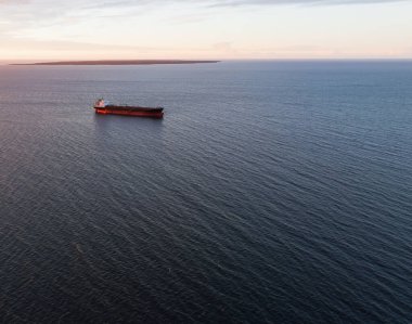 Şafak vakti Baltık Denizi 'nin engin ve sakin sularında seyreden yalnız bir kargo gemisinin destansı görüntüsü..