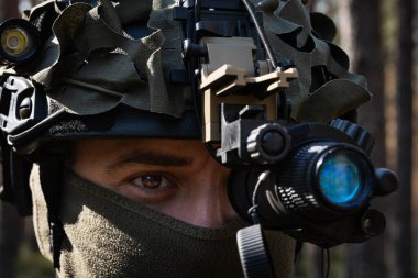 Ormandaki bir operasyon sırasında taktik miğferli ve gece görüş cihazlı bir özel kuvvetler askerinin yakın çekimi.. 