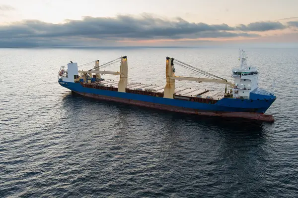 Deniz taşımacılığı ve lojistik: Baltık Denizi 'nde bulutlu bir gökyüzüne karşı ticari bir geminin hava görüntüsü.