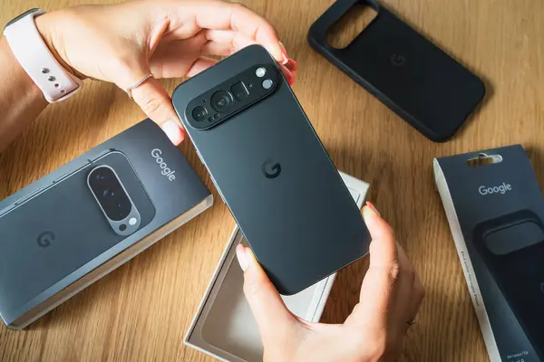 Tallinn, Estonya - 6 Temmuz 2025: Tahta bir masada boks yaptıktan sonra yeni Google Pikselli akıllı telefonu bir kadının elleri tutuyor.