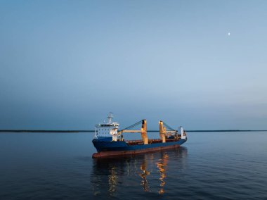 Estonya açıklarında sakin bir akşamda büyük bir kargo gemisi (büyük bir yük gemisi) Baltık Denizi 'nin sakin sularına demir atmıştır..
