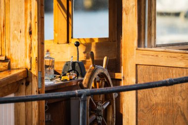 Günbatımının sıcacık ışığında eski bir ahşap teknenin kaptanının köprüsü. Dümen ve kontrol kolları. Deniz yolculuğu kavramı.