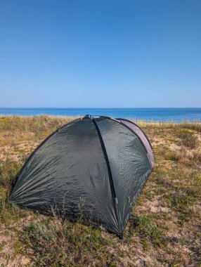 Estonya, Nova 'da kumlu bir sahildeki çadırın dikey görüntüsü. Tenha yaz kampı, seyahat ve kıyı macerası konsepti..