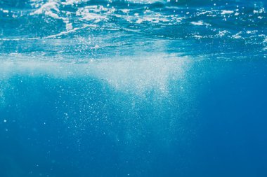 Saint-Jean-Cap-Ferrat 'ın berrak mavi sularında güneşli deniz yüzeyine yükselen hava kabarcıklarıyla ferahlatıcı bir su altı sahnesi..