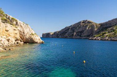 Fransa 'nın Marsilya kentindeki Calanques Ulusal Parkı' nın ikonik kireçtaşı kayalıkları Akdeniz 'in büyüleyici turkuaz suyunu çerçeveliyor..