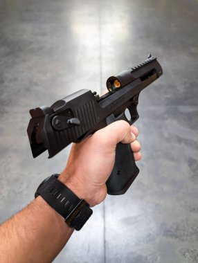 28 Ağustos 2025, Baltık Eyaleti: Bir adam bir Çöl Kartalı 44 'lük Magnum yarı otomatik tabancayı kapalı bir atış poligonunda tutuyordu..