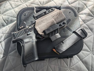 BALTIC REGION - 3 Ekim 2025: kırmızı nokta görüşü ve gizli bir silah kılıfı da dahil olmak üzere modern aksesuarlı düz bir Glock tabancası..