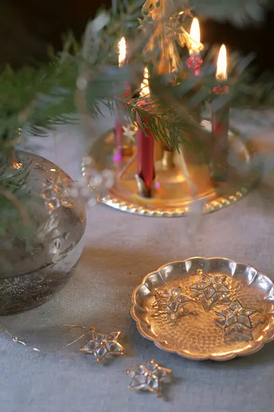 Noel piramidinin arka planında yanan mumlarla bir Noel ağacı için altın çerçeveli dekoratif kristal yıldızlar.