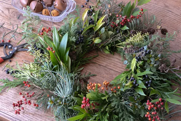 Yapım sırasında çiçekçinin masasındaki doğal malzemelerden yapılmış Noel çelengi.
