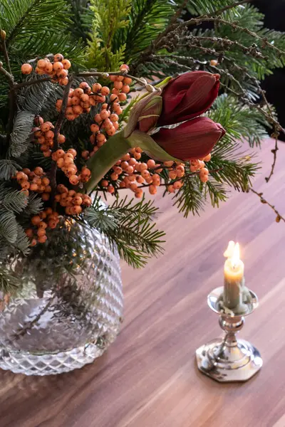 Kış buketi kozalaklı dallar, hippeastrumlar, ilex ve mum, Noel için masanın üstünde dekor..