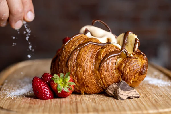 Çilekli muzlu ve dondurmalı kruvasan üzerine hindistan cevizi serpiyorum.