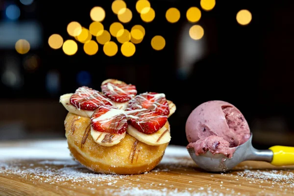 Tahta ve hindistan cevizli dondurmanın yanında lezzetli çilek ve muzlu çörek.