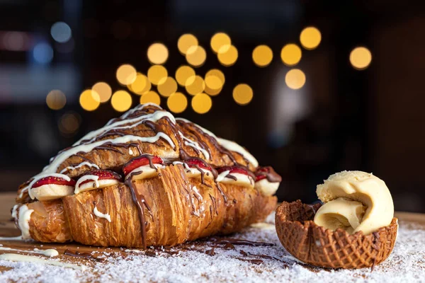 Lezzetli çilek ve muzlu kruvasan. Tahta tepside hindistan cevizi.