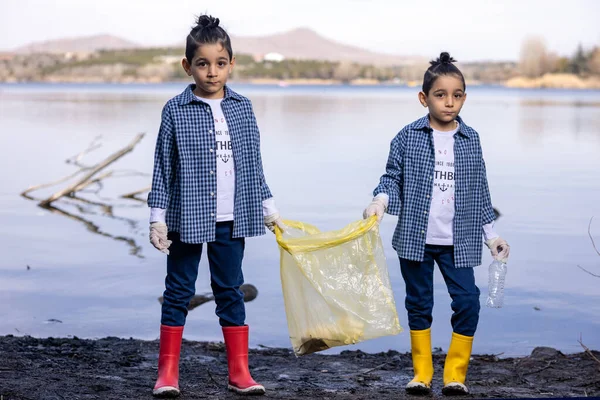 Doğada Gölde Çöp Toplayan İkiz Çocuklar Kameraya Bakıyor