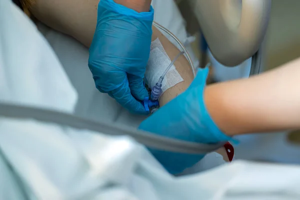 Hemşire, ameliyata giren hastaya damar erişimi açtı.