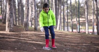 Boy Picks Up Trash Pet Bottle On The Ground In City Park Slow Motion