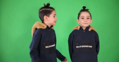 Twin Boys Kissing The Other And Smiling One On A Green Background