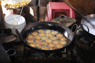 Kızartma tavasında kachori kızartıyorlar, sokak yemeklerinde, yağlı yiyeceklerde.