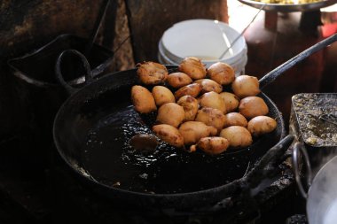 Kızartma tavasında kachori kızartıyorlar, sokak yemeklerinde, yağlı yiyeceklerde.