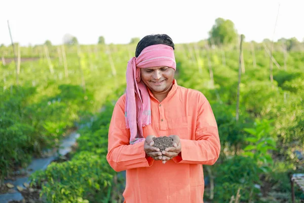 Happy Indian farmer, farmer holding soil in hands