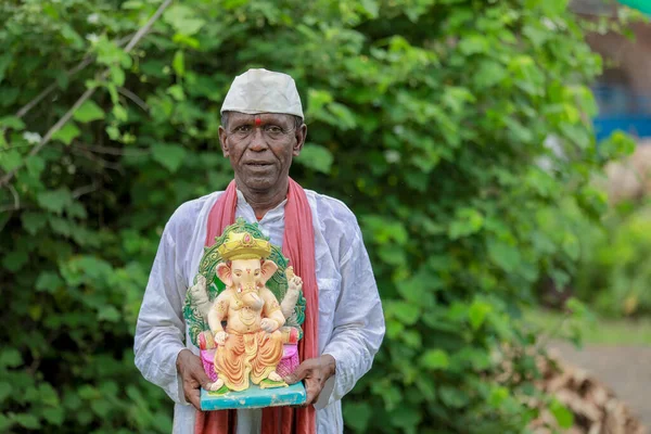 ガネーシャ卿アイドルを手に持っているインドの老人 幸せな老人 — ストック写真