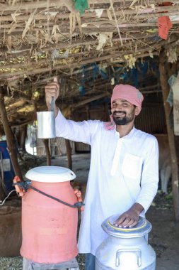 Mutlu Hintli çiftçi çiftlikte süt satıyor - süt üretimi kavramı tarım otobüsleri, kırsal Hindistan, büyüme ve tarım