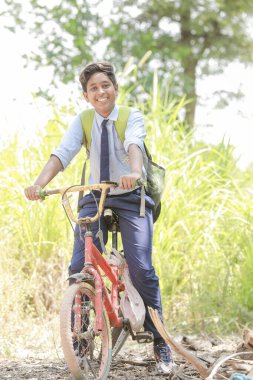 Bisiklet süren genç Hintli çocuk, mutlu çiftçi çocuklar.