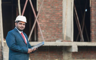 İnşaat şantiyesinde çalışan güvenlik üniformalı inşaat mühendisi portresi inşaat alanında inşaat işçisi kontrol ve kontrol projesi, yeni proje mimari mühendisliği.