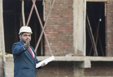 İnşaat şantiyesinde çalışan güvenlik üniformalı inşaat mühendisi portresi inşaat alanında inşaat işçisi kontrol ve kontrol projesi, yeni proje mimari mühendisliği.