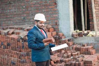 İnşaat şantiyesinde çalışan güvenlik üniformalı inşaat mühendisi portresi inşaat alanında inşaat işçisi kontrol ve kontrol projesi, yeni proje mimari mühendisliği.