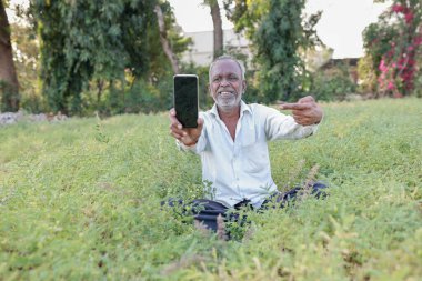 Hint nohut çiftliği, mutlu Hint çiftliği cep telefonunu elinde tutan, zavallı mutlu çiftçi.
