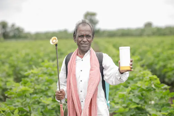 stock image Indian farmer working on farm field, spraying fertilizer on soil and plants. poor farmer , happy farmer , old farm worker