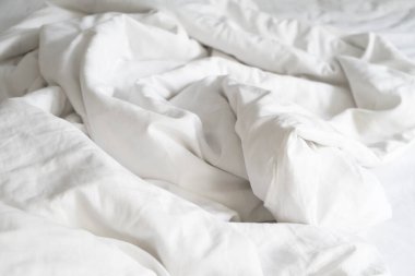 Yapılmamış yatak, kırışık yastık kılıfları, çarşaf ve yorgan..