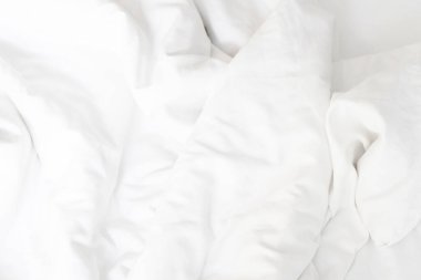 Yapılmamış yatak, kırışık yastık kılıfları, çarşaf ve yorgan..