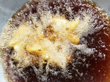 Büyük bir tavada kızgın yağda balık kızartmak kırsal bir mutfakta eski bir soba üzerinde...