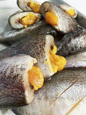 Kurutulmuş yılan derisi gourami satılık bir masaya konmuş. Tayland 'da popüler bir yiyecek koruma alanıdır..