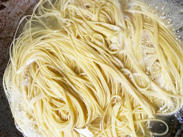 Stock image Top View Boiling Korean Instant Noodle or Spaghetti Pasta on Red Pan, Home Cooking Activity.