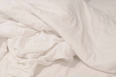  Oteldeki yatağın üzerindeki kırışıklık battaniyesi ve battaniyede güneş ışığı..