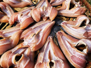 Kurutulmuş yılan başlı balıklar kuru güneşte bambu sepetinde..