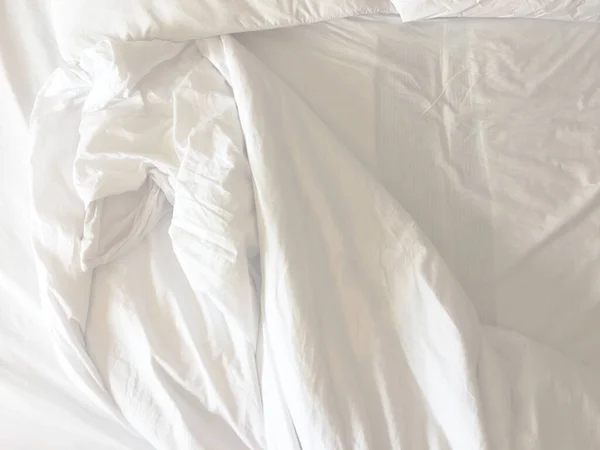 The crinkle blanket on the bed in the hotel with the sunlight on the blanket.