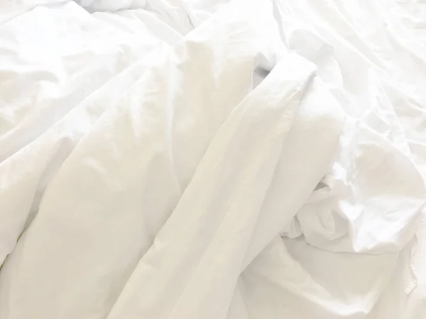 早上醒来后 卧室里皱巴巴的 凌乱的毛毯和白色的枕头 长夜的睡眠 羽绒被和毛毯的细节 酒店卧室里一张铺着白色毛毯的未整理的床 — 图库照片