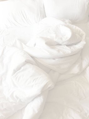 Beyaz yastık yatak ve yatak uzun bir uyku gece kış üzerinden, kırışıklık dağınık battaniye ile.