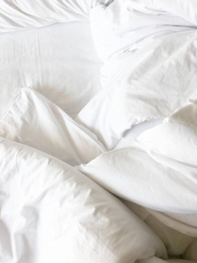 Beyaz yastık yatak ve yatak uzun bir uyku gece kış üzerinden, kırışıklık dağınık battaniye ile.