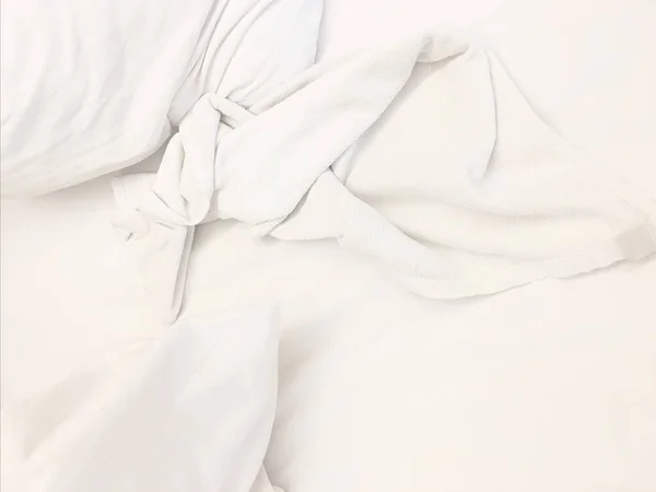 wrinkle messy blanket in bedroom after waking up in the morning, from sleeping in a long night, details of duvet and blanket, an unmade bed in hotel bedroom with white blanket.
