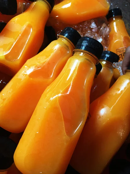 Orange juice bottles on the ice box.